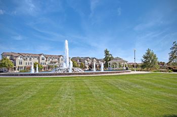 A fountain in a park in front of a house
